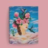 Agenda ilustrada con rostro femenino emergiendo de nubes, rodeado de flores rosas y picaflor en vuelo, sobre fondo celeste.